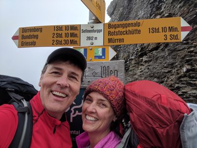 Geoff and Cindy at a trail signpost in the mountains